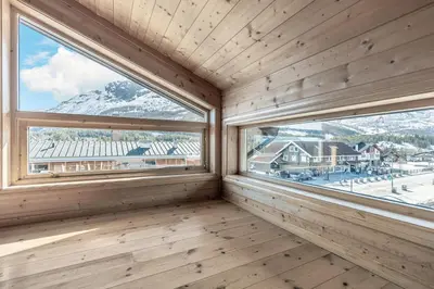 a wooden room with two windows with mountains at Skiers Lodge 2 - Saga Apartments in Hemsedal