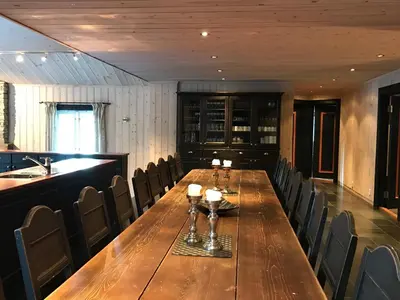 a dining room with a long wooden table and chairs at Kirkebøen Hytter in Hemsedal