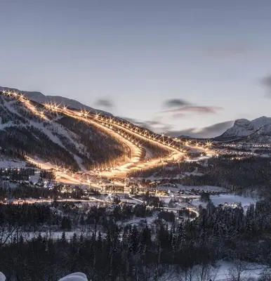 a city with lights on a mountain in the snow at Kirkebøen Hytter in Hemsedal
