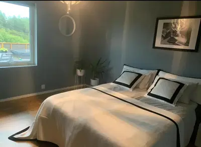 a bedroom with a large white bed with a window at Villa with jacuzzi in Nord Bjørøy
