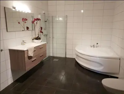 a bathroom with a tub and a sink and a toilet at Villa with jacuzzi in Nord Bjørøy