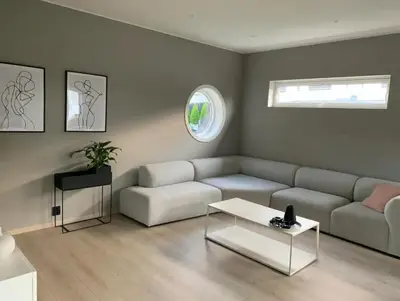 a living room with a couch and a table at Villa with jacuzzi in Nord Bjørøy