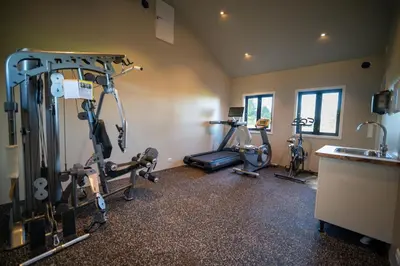 a gym with three exercise bikes in a room at Godo Lodge in Godøy