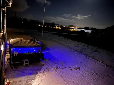 a bed with purple lights on the snow at night at Godo Lodge in Godøy