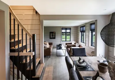 a living room and dining room with a staircase at Godo Lodge in Godøy
