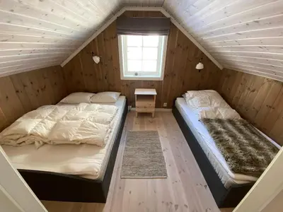 two beds in a room with wooden walls at Endely - ski inn / ut in Rauland