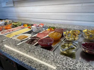 a counter with many different bowls of food on it at BORG Sommerhotell in Ålesund