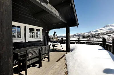 a house with a deck with snow on it at Utsikten in Sykkylven