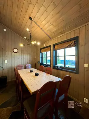 a dining room with a large wooden table and chairs at Large cabin at Sjusjøen with sauna, fireplace, view and cross-country skiing in Ringsaker
