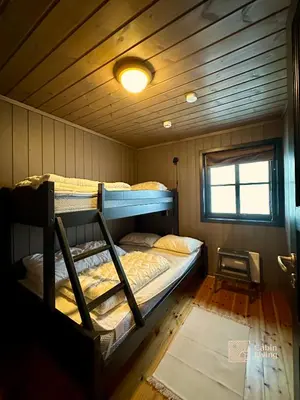 two bunk beds in a room with a ceiling at Large cabin at Sjusjøen with sauna, fireplace, view and cross-country skiing in Ringsaker