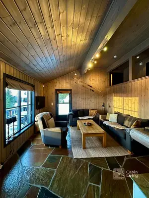 a living room with a couch and a table at Large cabin at Sjusjøen with sauna, fireplace, view and cross-country skiing in Ringsaker