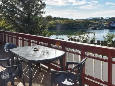 a table and chairs on a balcony with a view of a river at 6 person holiday home in Bud-By Traum in Bud