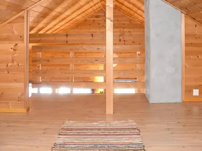 an empty room with wooden walls and a rug at 6 person holiday home in Bud-By Traum in Bud