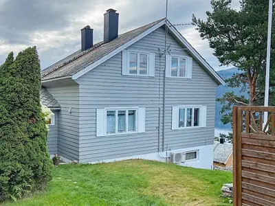 a gray house with a tree and a fence at 6 person holiday home in Utvik in Utvik