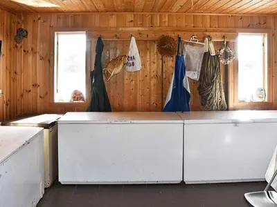 a kitchen with white cabinets and two windows at 6 person holiday home in Bud-By Traum in Bud