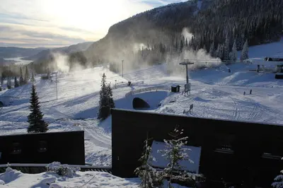a snow covered slope with people skiing down a mountain at Kvitfjell Alpinhytter Kvitfjellvegen 492 in Kvitfjell