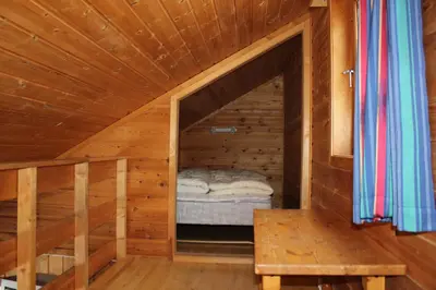 a small room with a bed in a wooden cabin at Kvitfjell Alpinhytter Kvitfjellvegen 492 in Kvitfjell