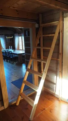 a wooden staircase in a room with a dining room at Klævold utleigehytte in Klevoll
