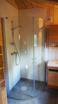 a shower in a bathroom with a glass door at Klævold utleigehytte in Klevoll
