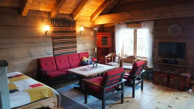 a living room with a red couch and a table at Klævold utleigehytte in Klevoll