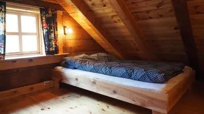 a bedroom with a bed in a wooden cabin at Klævold utleigehytte in Klevoll