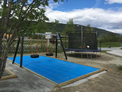 a playground with a swing and a basketball hoop at Øen Turistsenter Apartments in Geilo