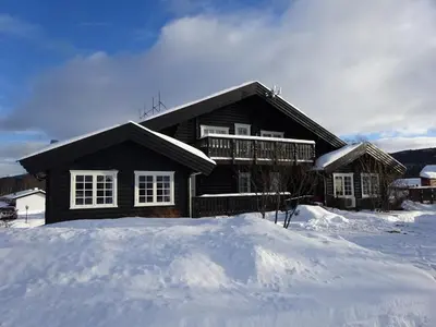a house with a pile of snow in front of it at Øen Turistsenter Apartments in Geilo