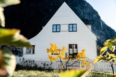a white house with a tree in front of it at Trolltunga Living in Tysso