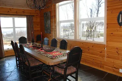 a dining room with a table and chairs and windows at Magnesplass - Dagalifjell in Dagali