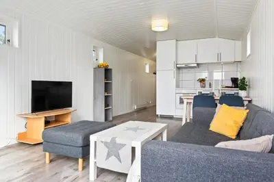 a living room with a couch and a tv at Topcamp Onsakervika - Tyrifjorden in Svensrud
