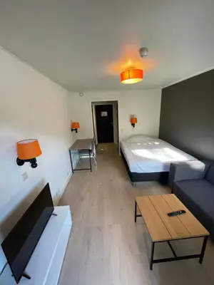 a room with a bed and a couch and a table at Namsen Hotell in Namsos