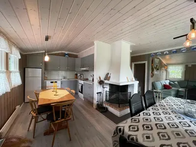 a kitchen and living room with a table and a fireplace at Sigurdhytta in Ål