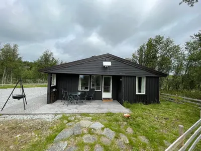 a small black cabin with a wooden deck at Sigurdhytta in Ål