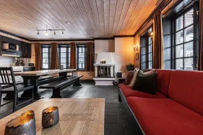 a living room with a red couch and a table at Tinden Apartments in Hemsedal