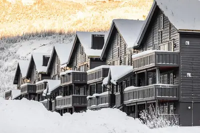 a large building covered in snow in the snow at Tinden Apartments in Hemsedal