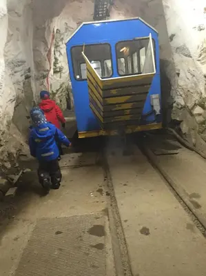 two people are standing next to a blue train at Gausta View in Gaustablikk