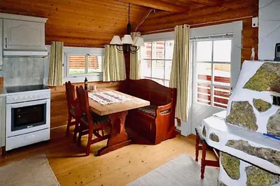 a kitchen with a table and a bed in a room at Cozy cottage in central Beitostølen with Sauna in Beitostøl
