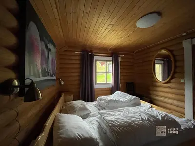 a bedroom with a bed in a wooden room at Cozy cottage in central Beitostølen with Sauna in Beitostøl