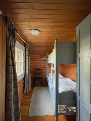 a bedroom with a bunk bed in a log cabin at Cozy cottage in central Beitostølen with Sauna in Beitostøl
