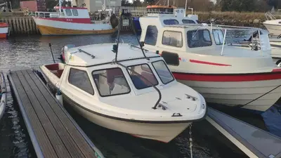 two boats are docked at a dock in the water at Airbnb and Booking at Postvegen 95 in Vigra