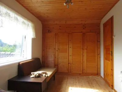 a dog laying on a couch in a room with a window at Airbnb and Booking at Postvegen 95 in Vigra