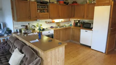 a kitchen with wooden cabinets and a white refrigerator at Airbnb and Booking at Postvegen 95 in Vigra