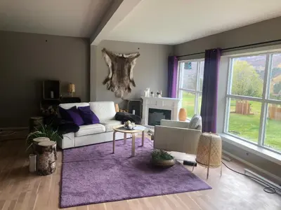 a living room with a white couch and a purple rug at Hallingskarvet Fjellstue as in Hovet