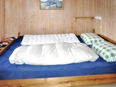 a bed with white sheets and pillows in a room at 6 person holiday home in VATNE-By Traum in Vatne