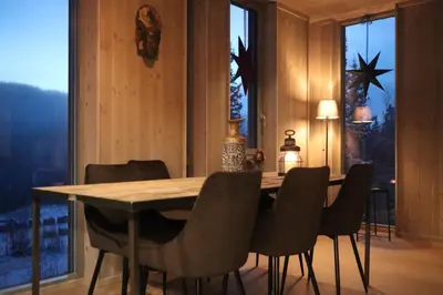 a dining room with a wooden table and chairs at Cozy Apartment by the slopes in Kvitfjell Vest in Favang