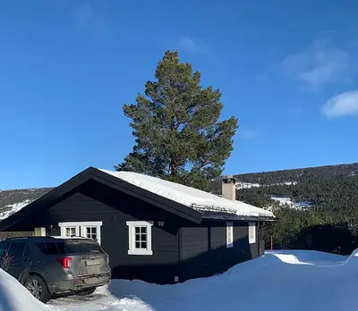 a car parked in front of a house covered in snow at Uvdalhytta - close to cross country and downhill skiing in Uvdal