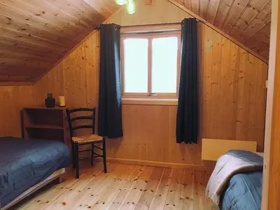 a bedroom with a window and a bed and a chair at Seaside 3-bedroom House in Svelgen