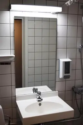 a bathroom with a white sink and a mirror at Rjukan Hotell in Rjukan