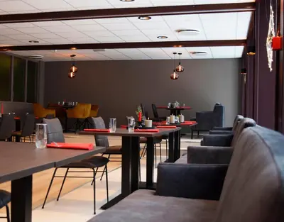 a dining room with tables and chairs and lights at Rjukan Hotell in Rjukan