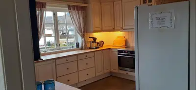 a kitchen with a white refrigerator and a window at Beitostølen Hytter in Beitostøl
